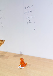 牛島光太郎の作品『組み合わせの方法』。日用品を組み合わせたモノと壁に油性ペンで言葉（文字）を書いた作品。