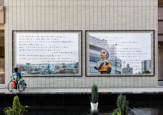牛島光太郎の作品『何も起きない話』。国内外で集めた古着をつなぎ合せた作品。つぎはぎした布に文字（言葉）を刺繍。