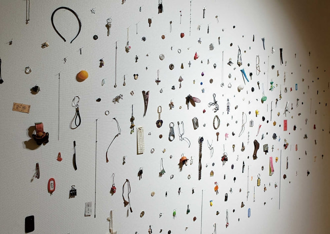牛島光太郎の作品『みちのもの』。国内外の路上や駅などで拾い集めているモノ（キーホルダーやボタンやピアスなど）を展示した作品。