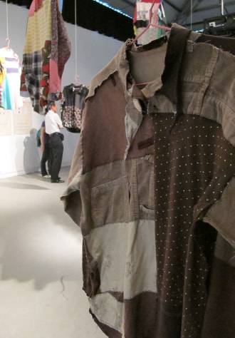 牛島光太郎の作品『何も起きない話』。国内外で集めた古着をつなぎ合せた作品。つぎはぎした布に文字（言葉）を刺繍。
