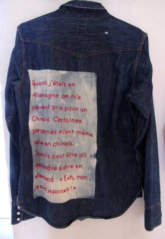 牛島光太郎の作品『old clothes』。漂白した古着に文字（言葉）を刺繍した作品。