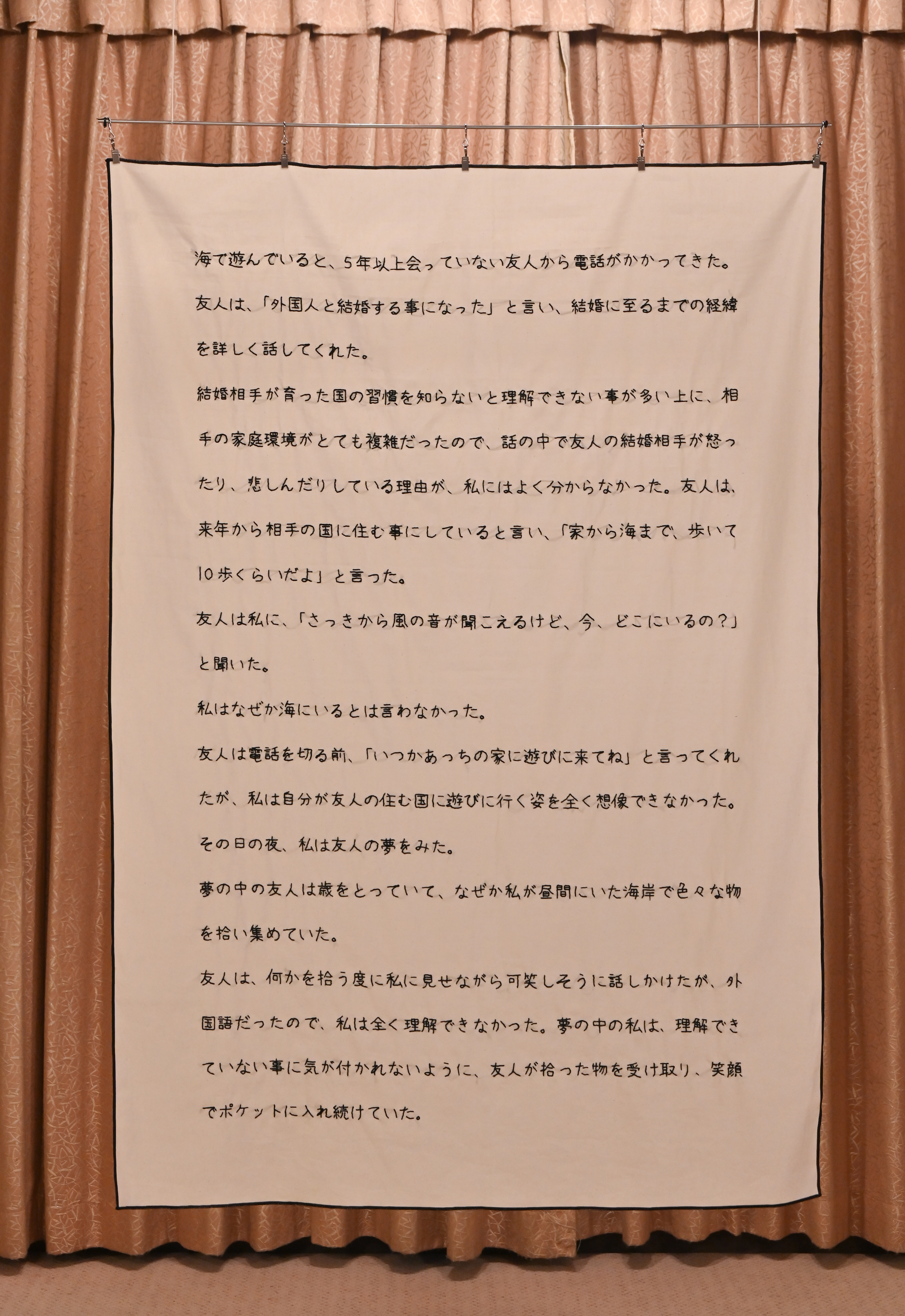 牛島光太郎の作品『意図的な偶然』。日常生活で実際に拾ったモノや、思い入れのあるモノと文字を刺繍した布で構成する作品。