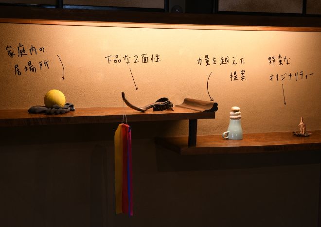 牛島光太郎の作品『組み合せの方法』。日用品を組み合わせたモノと壁に油性ペンで言葉（文字）を書いた作品。