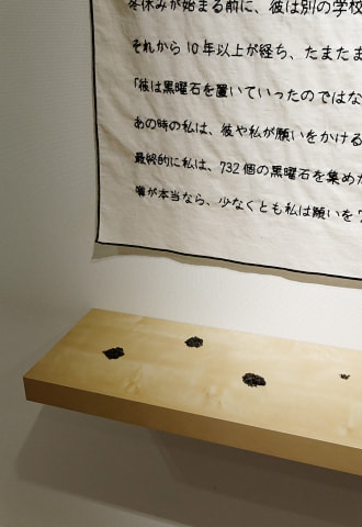 牛島光太郎の作品『意図的な偶然』。日常生活で実際に拾ったモノや、思い入れのあるモノと文字を刺繍した布で構成する作品。