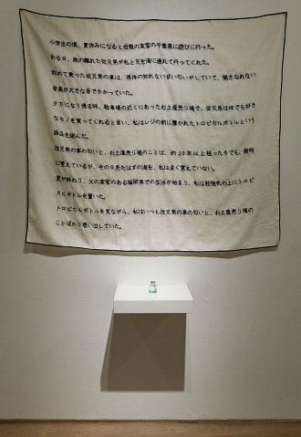 牛島光太郎の作品『意図的な偶然』。日常生活で実際に拾ったモノや、思い入れのあるモノと文字を刺繍した布で構成する作品。