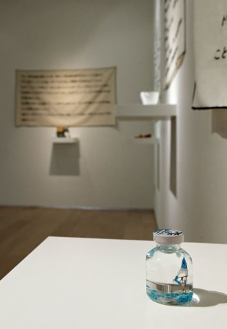 牛島光太郎の作品『意図的な偶然』。日常生活で実際に拾ったモノや、思い入れのあるモノと文字を刺繍した布で構成する作品。