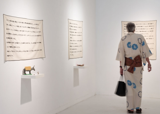 牛島光太郎の作品『意図的な偶然』。日常生活で実際に拾ったモノや、思い入れのあるモノと文字を刺繍した布で構成する作品。