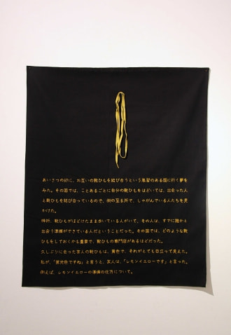 牛島光太郎の作品『意図的な偶然』。日常生活で実際に拾ったモノや、思い入れのあるモノと文字を刺繍した布で構成する作品。