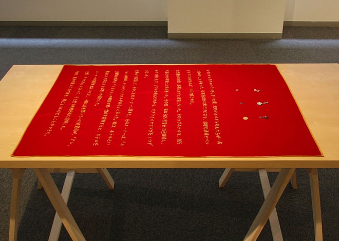 牛島光太郎の作品『意図的な偶然』。日常生活で実際に拾ったモノや、思い入れのあるモノと文字を刺繍した布で構成する作品。