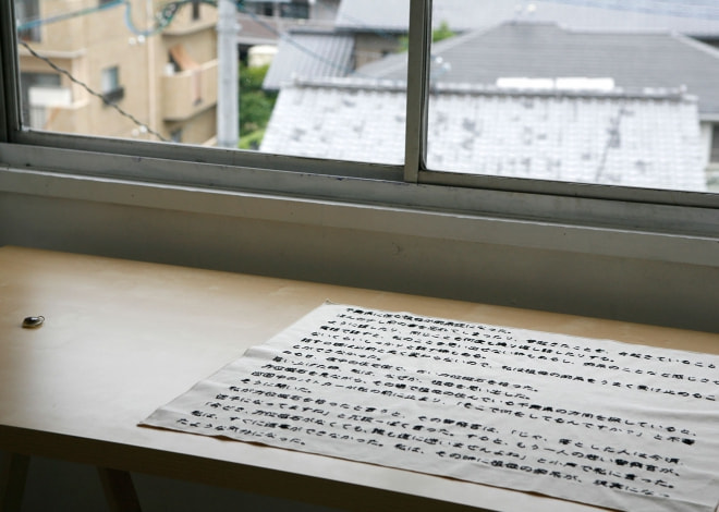 牛島光太郎の作品『意図的な偶然』。日常生活で実際に拾ったモノや、思い入れのあるモノと文字を刺繍した布で構成する作品。