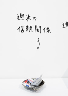 牛島光太郎の作品『組み合わせの方法』。日用品を組み合わせたモノと壁に油性ペンで言葉（文字）を書いた作品。
