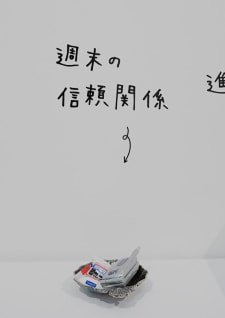 牛島光太郎の作品『組み合わせの方法』。日用品を組み合わせたモノと壁に油性ペンで言葉（文字）を書いた作品。