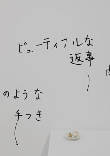 牛島光太郎の作品『組み合わせの方法』。日用品を組み合わせたモノと壁に油性ペンで言葉（文字）を書いた作品。