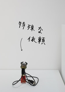 牛島光太郎の作品『組み合わせの方法』。日用品を組み合わせたモノと壁に油性ペンで言葉（文字）を書いた作品。