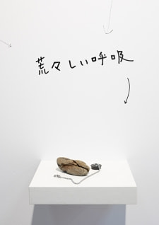 牛島光太郎の作品『組み合わせの方法』。日用品を組み合わせたモノと壁に油性ペンで言葉（文字）を書いた作品。