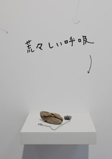 牛島光太郎の作品『組み合わせの方法』。日用品を組み合わせたモノと壁に油性ペンで言葉(文字)を書いた作品。