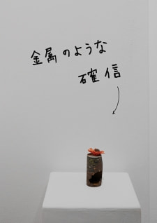 牛島光太郎の作品『組み合わせの方法』。日用品を組み合わせたモノと壁に油性ペンで言葉（文字）を書いた作品。