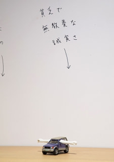 牛島光太郎の作品『組み合わせの方法』。日用品を組み合わせたモノと壁に油性ペンで言葉（文字）を書いた作品。