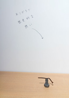 牛島光太郎の作品『組み合わせの方法』。日用品を組み合わせたモノと壁に油性ペンで言葉(文字)を書いた作品。