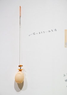 牛島光太郎の作品『組み合わせの方法』。日用品を組み合わせたモノと壁に油性ペンで言葉（文字）を書いた作品。