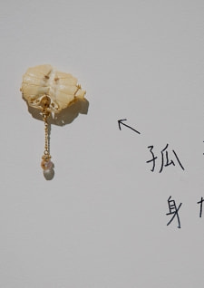牛島光太郎の作品『組み合わせの方法』。日用品を組み合わせたモノと壁に油性ペンで言葉（文字）を書いた作品。