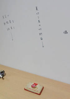 牛島光太郎の作品『組み合わせの方法』。日用品を組み合わせたモノと壁に油性ペンで言葉（文字）を書いた作品。