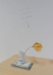 牛島光太郎の作品『組み合わせの方法』。日用品を組み合わせたモノと壁に油性ペンで言葉(文字)を書いた作品。