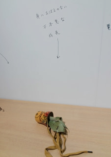 牛島光太郎の作品『組み合わせの方法』。日用品を組み合わせたモノと壁に油性ペンで言葉（文字）を書いた作品。