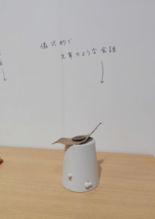 牛島光太郎の作品『組み合わせの方法』。日用品を組み合わせたモノと壁に油性ペンで言葉（文字）を書いた作品。