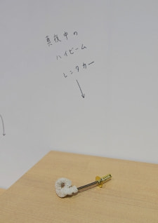 牛島光太郎の作品『組み合わせの方法』。日用品を組み合わせたモノと壁に油性ペンで言葉（文字）を書いた作品。