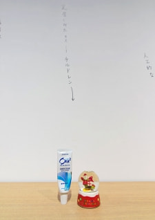 牛島光太郎の作品『組み合わせの方法』。日用品を組み合わせたモノと壁に油性ペンで言葉（文字）を書いた作品。
