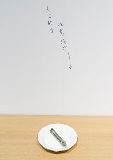 牛島光太郎の作品『組み合わせの方法』。日用品を組み合わせたモノと壁に油性ペンで言葉（文字）を書いた作品。