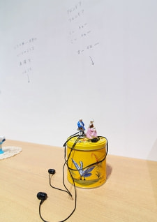 牛島光太郎の作品『組み合わせの方法』。日用品を組み合わせたモノと壁に油性ペンで言葉（文字）を書いた作品。
