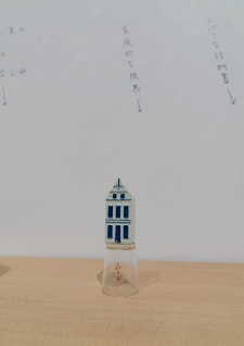 牛島光太郎の作品『組み合わせの方法』。日用品を組み合わせたモノと壁に油性ペンで言葉(文字)を書いた作品。