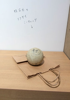 牛島光太郎の作品『組み合わせの方法』。日用品を組み合わせたモノと壁に油性ペンで言葉（文字）を書いた作品。