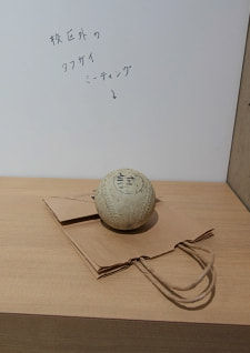 牛島光太郎の作品『組み合わせの方法』。日用品を組み合わせたモノと壁に油性ペンで言葉（文字）を書いた作品。