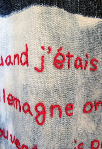 牛島光太郎の作品『old clothes』。漂白した古着に文字（言葉）を刺繍した作品。